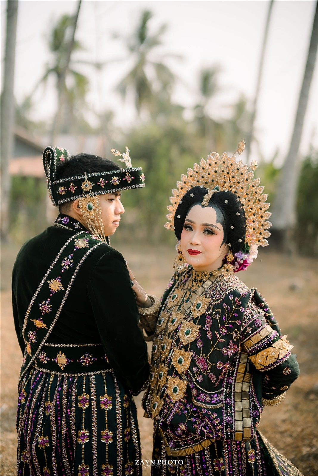 Potret pasangan dengan busana adat di antara pepohonan