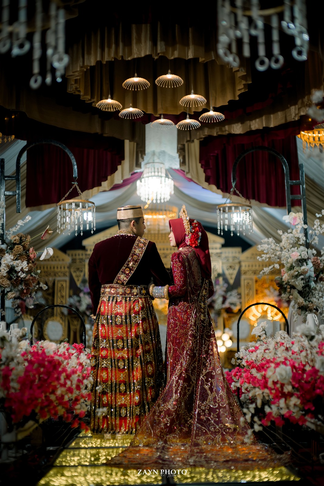 Pasangan pengantin dengan busana adat di pelaminan